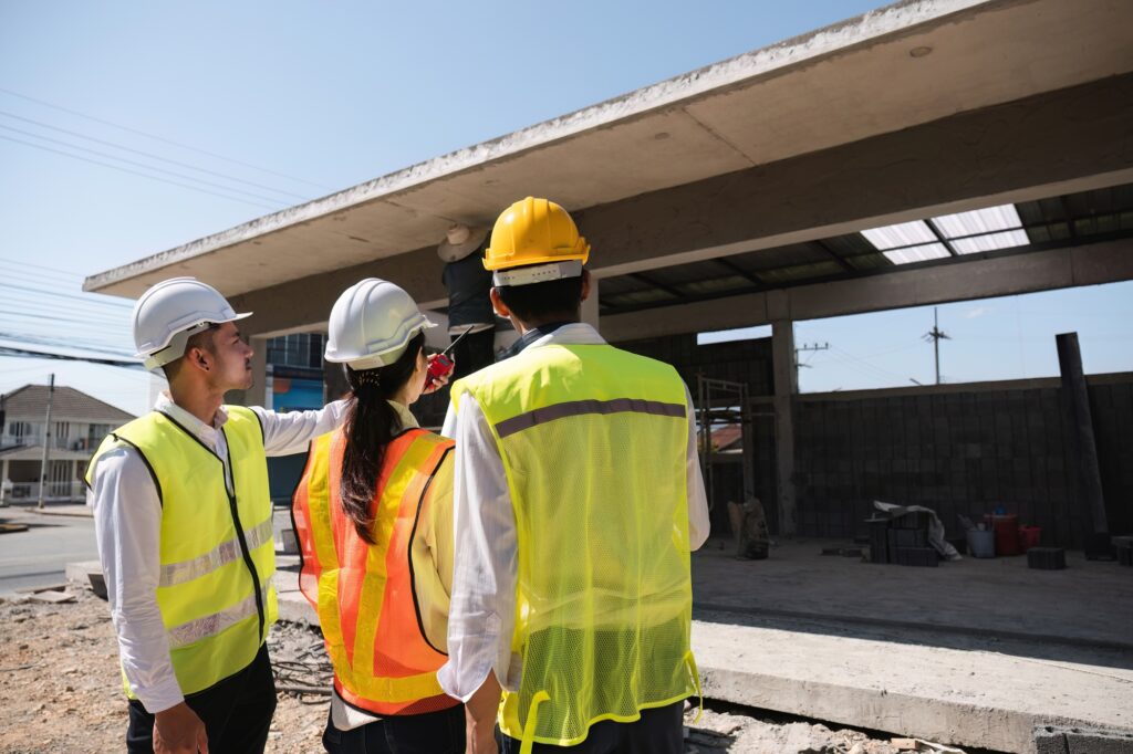 Team of professional civil engineers and architects holding project plan paper, supervising and