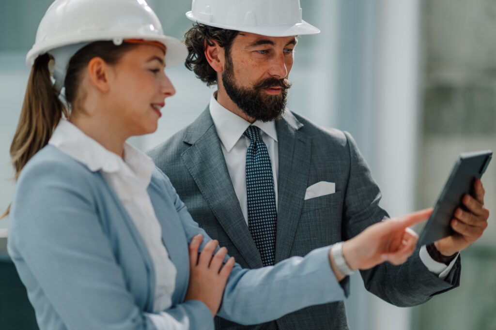 Architects consulting using digital tablet on construction site